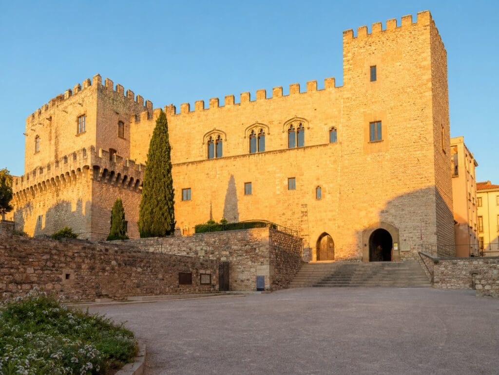 Palais des Rois de Majorque baigné par la lumière dorée de fin d'après-midi